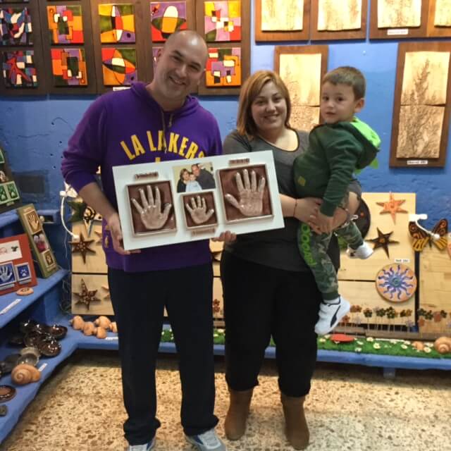 familia contenta con sus huellas cerámicas en tienda huelladebebes