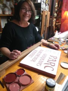 La ceramista Marisa Alvarez pintando rótulo